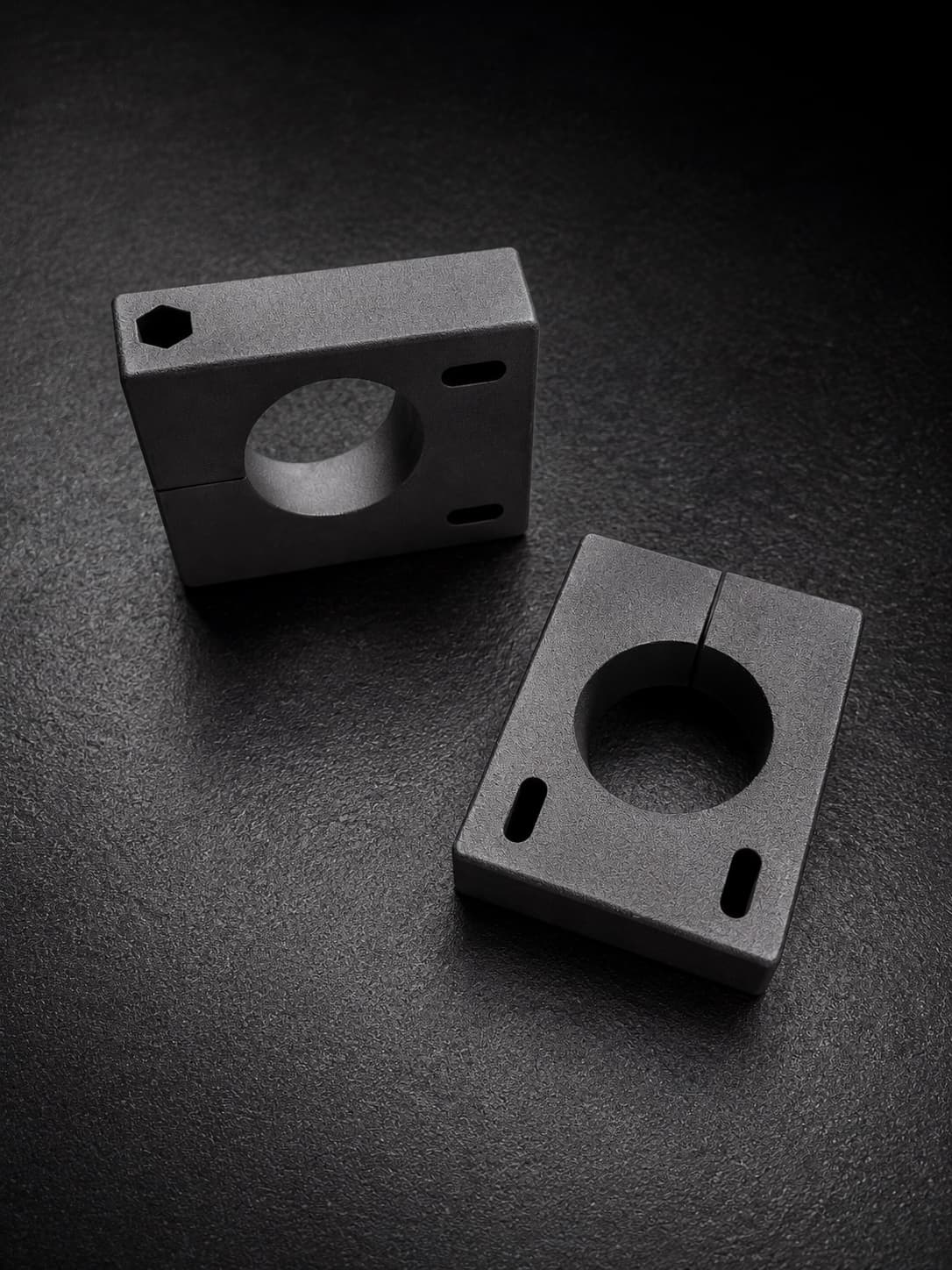 Custom SLS-printed angled clamp fixturing blocks in Nylon 12 Tough on a dark surface